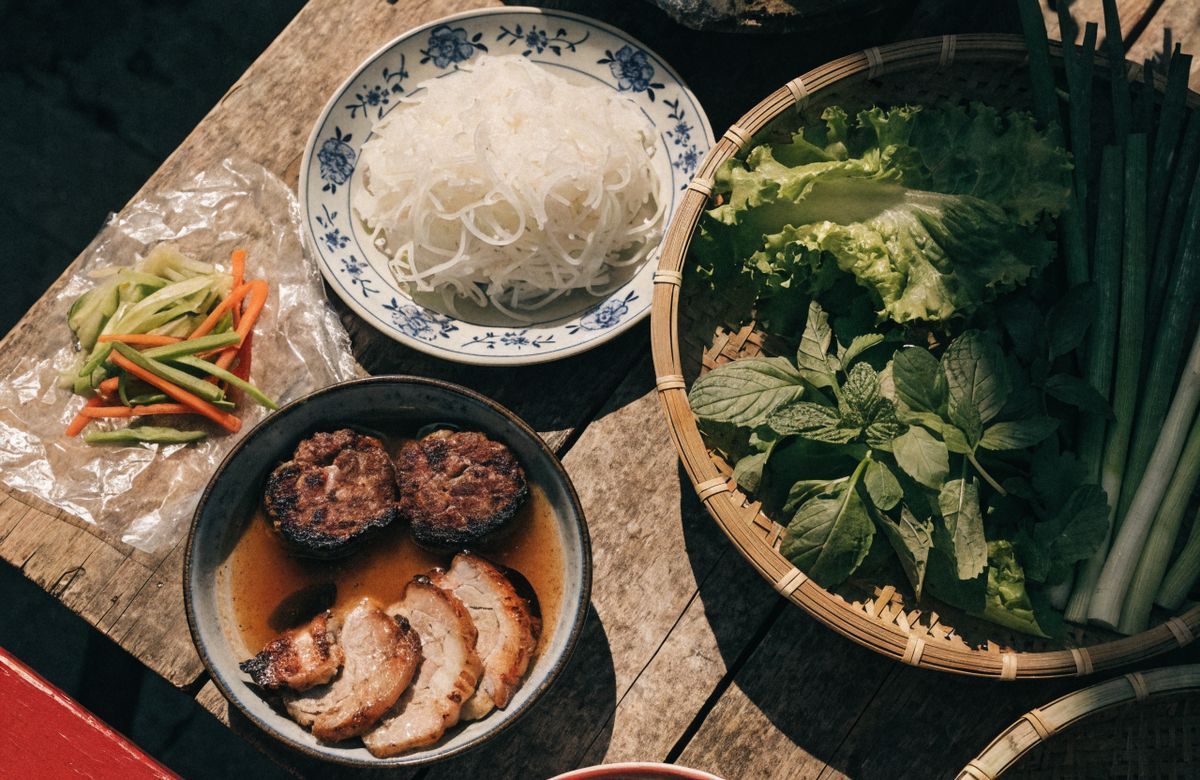 Mâm bún chả Hà Nội với bát nước chấm chứa chả viên và chả miếng, đĩa bún và rổ rau sống